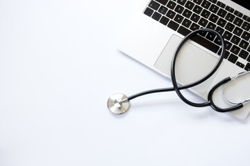 Laptop and stethoscope on white background, top view