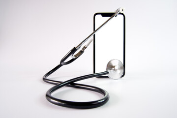 Smartphone and stethoscope on white background