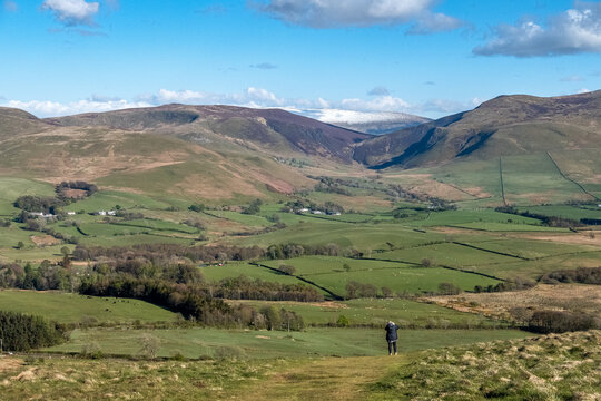 View of the countryside from the top of the hill, with person in the foreground