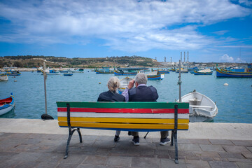 Couple sitting on a bench in the harbour