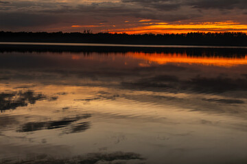 The breathtaking reflection of a stunning sunset creates an enchanting scene over tranquil waters