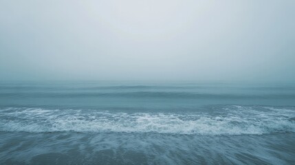 Fototapeta premium The ocean is calm and the sky is cloudy. The water is a deep blue color. The sky is overcast and the water is still