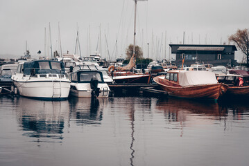 Yacht parking in seaport, boats in water lake, landscape of marina on cloudy day