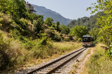 Obraz premium Train on the narrow gauge Odontotos railway in Vouraikos Gorge on Peloponnese peninsula, Greece.