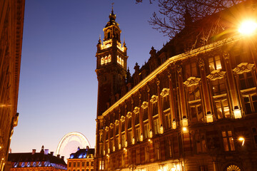 Obraz premium Lille, old facades in the center, the belfry of the Chamber of Commerce in background at night . France.