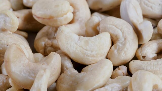Close-up, slider shot of fresh cashew nuts in a heap. Depth of field, selective focus. Food, nutrition, healthy eating, snacks, ingredient concepts. 4k