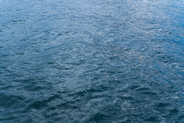 The smooth surface of the sea with an abstract pattern reflects the depth and purity of nature. The photo features bright shades of blue.