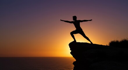 Silhouette of man in warrior pose at sunset overlooking ocean