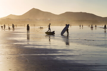 Tourists and surfers on Famara beach, Lanzarote