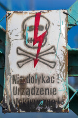 Znak ostrzegawczy - NIE DOTYKAĆ! URZĄDZENIE ELEKTRYCZNE! - całkowicie zużyte przez upływ czasu. Znak ostrzegający przed porażeniem prądem umieszczony na urządzeniu elektrycznym. Stara tabliczka .