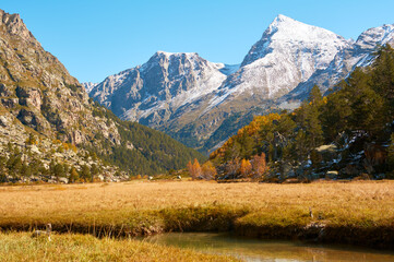 Beautiful mountain scenery. River, valley, snow, blue sky, white clouds.