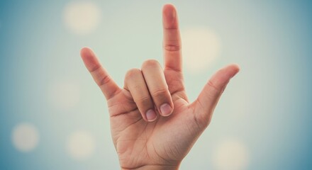 Expressing love in sign language on soft blue background