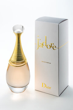 Italy - December 30, 2024: J'adore Dior perfume on white background, 100 ml ampoule of eau de parfum with packaging with gold logos and lettering