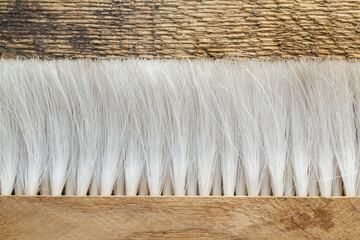 a wooden brush with stiff long white bristles