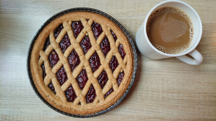 Homemade tart with coffee on wooden table