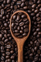 Fototapeta premium Wooden Spoon of Coffee Beans on Coffee Bean Background