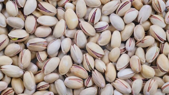 Top down view, slider shot of fresh pistachio nuts in a heap. Food, nutrition, healthy eating, snacks, ingredient concepts. 4k