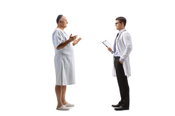Mature male patient in a hospital gown and a doctor having a conversation