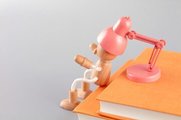 The wooden man is being charged by the book