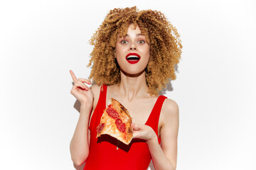 Young woman with curly hair joyfully holding a slice of pizza, wearing a red swimsuit, bright red...