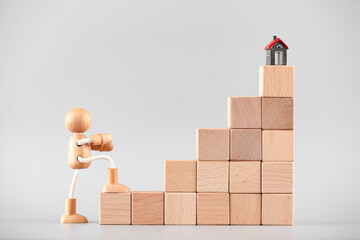 Model houses and wooden people walking upward