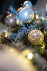 Decorative baubles on a festive tree with soft bokeh lights, radiating holiday magic. Perfect for promoting Christmas events, home décor, or seasonal greetings.
