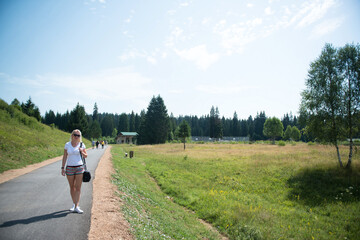 Woman Walking With Small Bag Surrounded By Nature