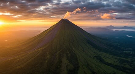 Majestic volcano at sunrise with rolling clouds and lush greenery