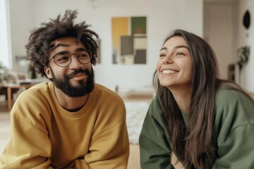 Happy multi ethnic couple smiling and looking up, enjoying their time together in the comfort of their home
