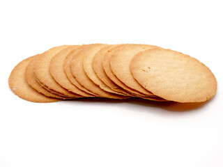 A close-up view of baked potato crisps placed on a white background, showcasing their golden-brown texture and thin, delicate slices