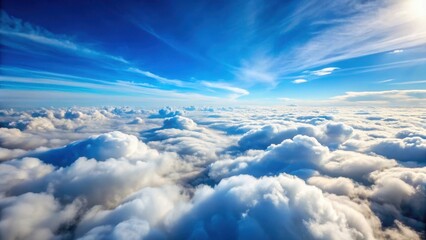 Soft blue sky with white fluffy clouds scattered in the horizon, aerial view