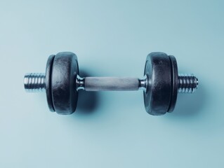 A black dumbbell on a light blue background, symbolizing fitness and strength training.