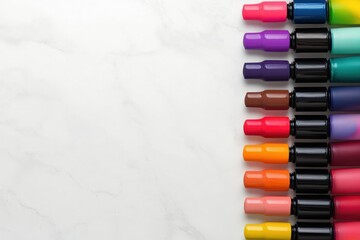 Fototapeta premium A close-up of vibrant nail polish bottles arranged in a gradient of colors on a marble countertop