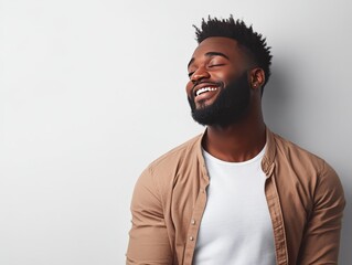 Obraz premium A smiling man with a beard, exuding confidence and joy against a neutral background.