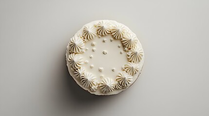 An overhead view of a round birthday cake with minimal decorations displayed on a plain white surface 