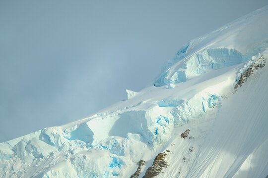 Fascinating Antarctica with a beautiful mountain covered with snow and ice with sunshine on the snowfields