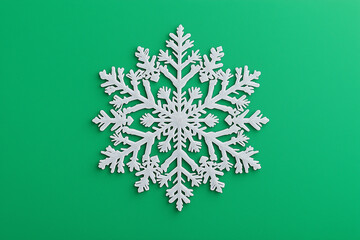 Decorative white snowflake on vibrant green background representing christmas, new year, and winter celebrations