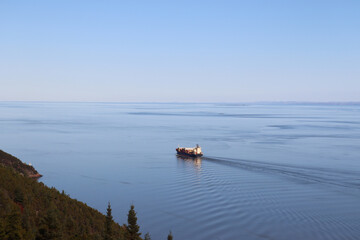 A riverside and a view from Charlevoix in Quebec. The St-Laurent river in autumn with islands, coastline and a big boat. Canada and Quebec country. An horizon background with blue water and sky.