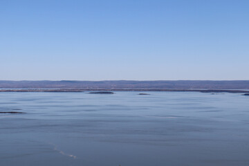 A riverside and a view from Charlevoix in Quebec. The St-Laurent river in autumn with islands and a coastline. Canada and Quebec country. An horizon background with blue water and sky.