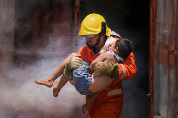 Firefighter holding child boy to save him in fire and smoke,Firemen rescue the boys from fire.