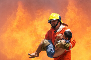 Firefighter holding child boy to save him in fire and smoke,Firemen rescue the boys from fire.