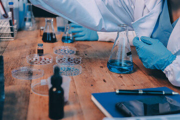 Blood test in the laboratory. Laboratory assistant working with the dispenser. Vacuum tubes with blood.