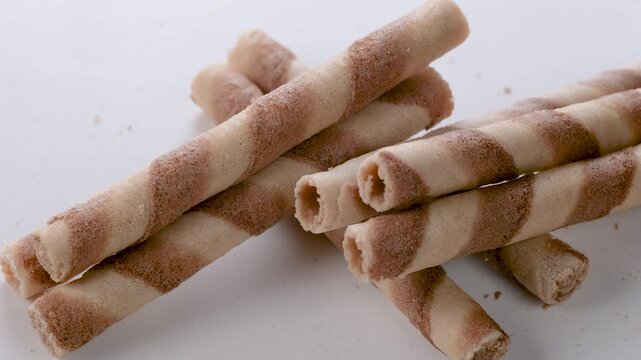 A stack of crispy wafer rolls with hazelnut cream in a close-up view. Slider shot. Depth of field, selective focus. Dessert, snack, sweets or confectionery treats concepts. 4k