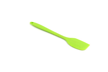 A Geen baking spatula on a white background