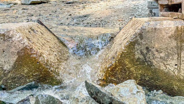 V-notch weir cut into a concrete retaining wall for water restriction 