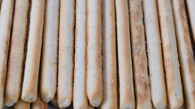 Stack of crunchy salted pretzel sticks. Slider shot. Food, nutrition, snack, ingredient concepts. 4k