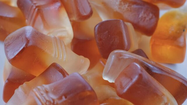 Close up view. Cola bottle shaped soft jelly bean candies. Slider shot. Confectionery, Candy and Desserts, Sweet Treats, Snacks concepts. 4k