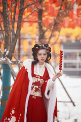 Obraz premium Asian girl wearing Chinese red Hanfu outdoors on a snowy day