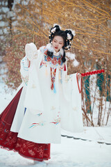 Asian girl wearing Ming Dynasty Hanfu outdoors after heavy snow