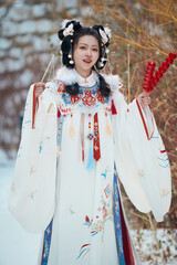 Asian girl wearing Ming Dynasty Hanfu outdoors after heavy snow
